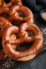 Oktoberfest concept card. Traditional Bavarian pretzels with beer bottle mug on old dark black rustic background. Perfect for Octoberfest. Oktoberfest food menu.