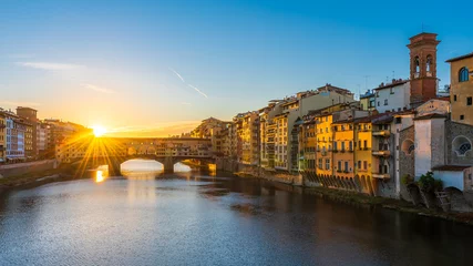 Fotobehang Ponte Vecchio A rising sun above the Ponte Vecchio in Florence early in the morning.