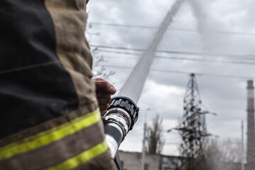 a fireman launches a jet of water from a fire nozzle