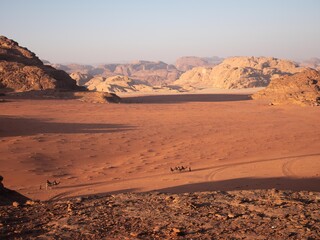 Wadi Rum desert with rock formations and golden sands.