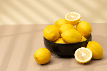  Still life yellow ripe lemons in a ceramic plate with a sprig of mint on the table. Copy space