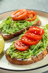 Avocado Toast and tomatoes on light background. Vegetarian food. Vegan menu. place for text, top view