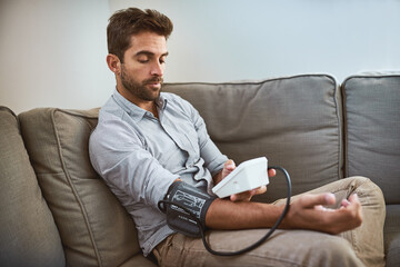 Hypertension, machine and man exam blood pressure in a home sofa or living room for medical or...