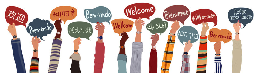 Raised arms and hands of multicultural people from different nations and continents holding speech bubbles with text -welcome- in various international languages.Communication.Equality
