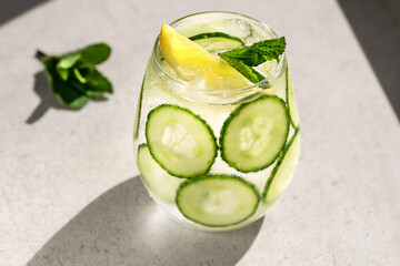 Cucumber, lemon, mint lemonade. Glass of cool water drink with cucumber, lemon and mint leaves.