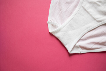 Fototapeta premium Top view of women's white panties on a pink background. Detail, gusset close-up. High seamless plain, part. Concept: top view advertising, shopping, advertising, mockup, copy space