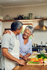Love, vegetables and old man with happy woman at kitchen counter, embrace and healthy marriage bonding in home. Happiness, help and cooking, senior couple with smile, hug and dinner in retirement.