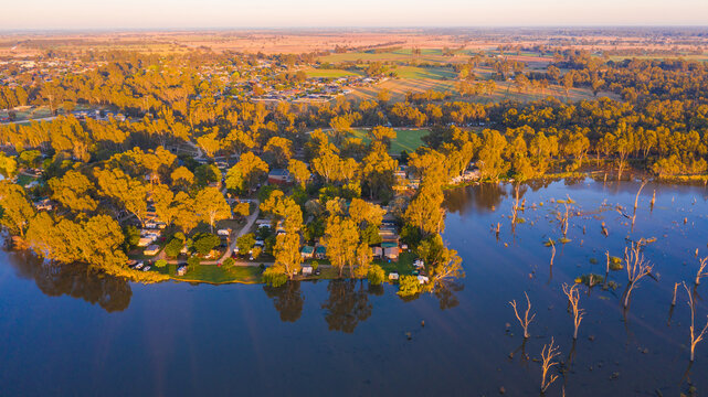 Aerial view of a caravan park on the banks of a river under golden morning sunshine