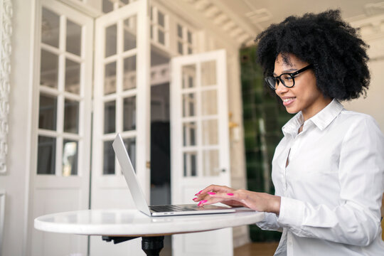 A startup entrepreneur is a young woman in an office in a white shirt using a laptop pc computer for analytics working.
