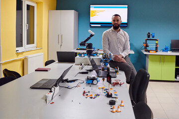  A bearded man in a modern robotics laboratory, immersed in research and surrounded by advanced...