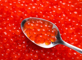 Red caviar in a spoon, background. Top view