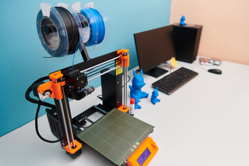 Modern 3d printer for creating 3d models and materials on the table in the laboratories next to the computer