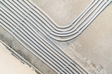 Electrical wiring in plastic corrugation on a concrete ceiling or wall.