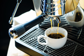 Electric coffee maker. The process of preparing a drink and filling a ceramic mug. Close-up. selective focus