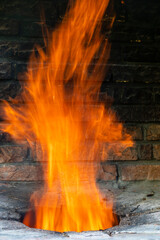 Big fire in a home tandoor at the cottage, closeup. Firewood is burned in a tandoor heating it before cooking meat