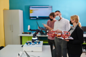  A group of students working together in a laboratory, dedicated to exploring the aerodynamic capabilities of a drone