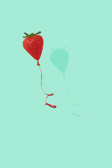 Strawberry balloon on bright green background. Minimal summer and food fun concept