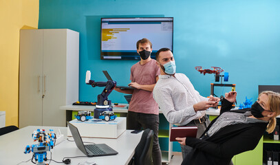  A group of students working together in a laboratory, dedicated to exploring the aerodynamic capabilities of a drone