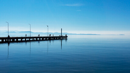 serenity in blue. people on the pier