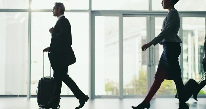 Business man, luggage and walking in airport terminal with corporate people. Professional male person walk with suitcase for international travel, flight and arrival or departure at a window