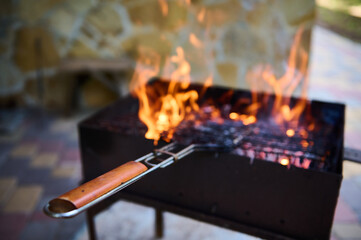 BBQ or Barbecue or Barbeque or Barbecue Charcoal Fire Grill. Selective focus. Close-up empty flaming charcoal grill with open fire, ready for product placement. Summer grilling ans chill out concept