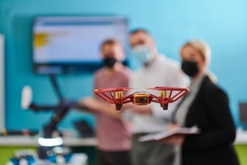  A group of students working together in a laboratory, dedicated to exploring the aerodynamic capabilities of a drone