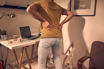 Man with hip, back, spine, hernia and sciatica pain at home.