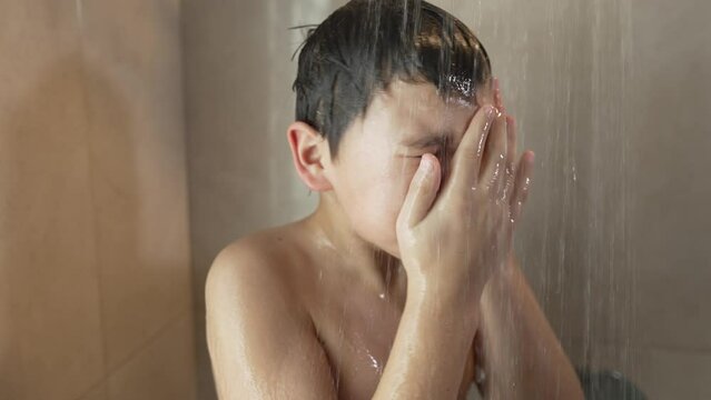 Boy takes a shower and washing face