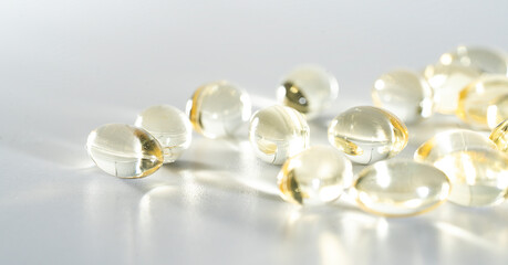 Vitamin D yellow supplement gel capsules, Fish Oil Omega 3 on white background,  macro shot 