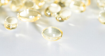 Vitamin D yellow supplement gel capsules, Fish Oil Omega 3 on white background, macro shot 