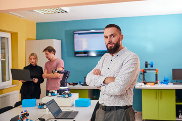 A group of colleagues working together in a robotics laboratory, focusing on the intricate fields of robotics and 3D printing. Showcase their dedication to innovation, as they engage in research