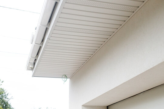 Facade renovation, thermal improvement and energy saving. Modern farmhouse roof soffit. Installation of soffit on wooden rafters. House exterior improvement