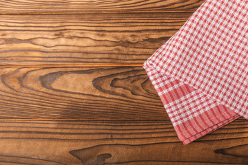Checkered kitchen cotton towels folded on a brown texture table. Kitchenware. Kitchen towel or textile napkin. Copy space for text. Place for text. Tablecloth.