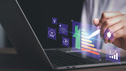 Energy efficiency rating and eco green home concept. Hand use laptop computer with house icon energy efficiency. Ecology house with low consumption on renovation with insulation. Show save cost icon.