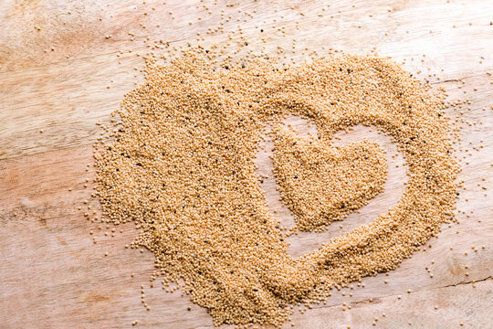 Amaranth seed abstract background. Heart on wooden table with seeds