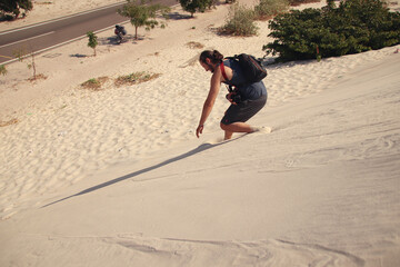 A carefree male Caucasian tourist running down the desert sand dunes in Mui ne, Vietnam