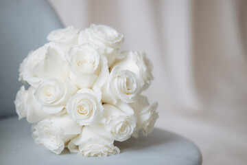 Wedding bouquet of white roses on a white background with soft focus and copy space.