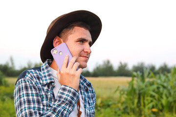 Farmer talking on the purple phone. In a flourishing field, a young farmer meticulously examines a...