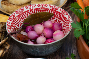 Pickled pearl onions in small tapas dish as part of a larger tapas or mezze meal