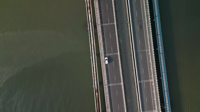 Aerial pedestal shot of a car parked on a road bridge. Pedestal shot of a road bridge. 4K drone footage of a road bridge.