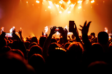 Fototapeta na wymiar Audience with raised hands on a dance floor at a music festival.