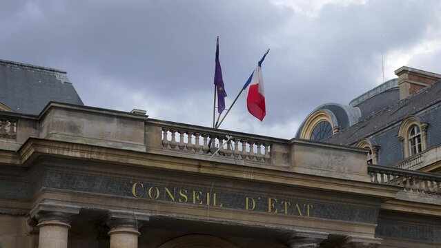 Close-up low-angle view of Council of State building with French flag and European Union Flag. French public institution that advises government, slow motion. Body of French national government.