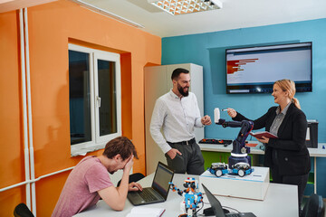 Obraz premium A group of colleagues working together in a robotics laboratory, focusing on the intricate fields of robotics and 3D printing. Showcase their dedication to innovation, as they engage in research