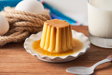 From above white plate with flan and spoon