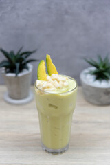 Glass of avocado smoothie on wooden table