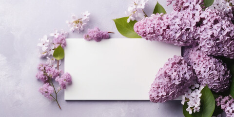 Blank white card in the center, surrounded by lilac flowers, white background top view, AI Generated