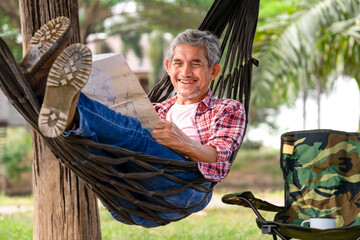 happy senior male with grey hair and beard wears checkered shirt relax at resort garden on...