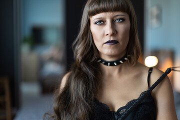 Woman with whip in leather clothes and a collar is going to play adult sexual games bdsm and...