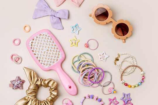 Set of baby girl hair accessories. Fashion hair bows, hair brush, hair clips, hairpins and hair elastics. Hairstyles for girls with stylish accessory.