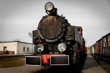 Vintage locomotive, steam train in an outdoor depot.